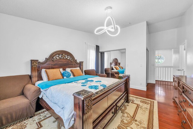 bedroom featuring baseboards, wood finished floors, and a chandelier