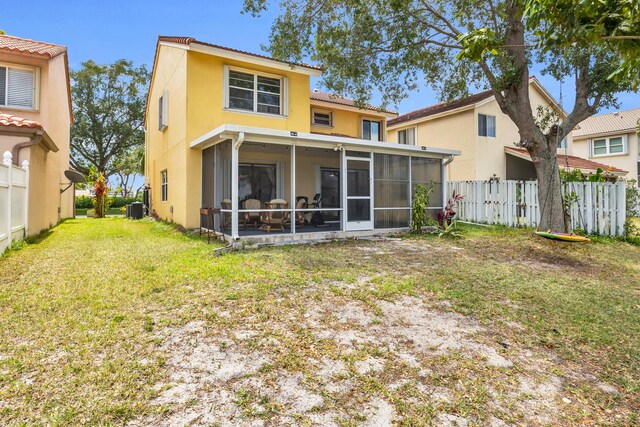 back of house with a sunroom, a yard, fence, and stucco siding