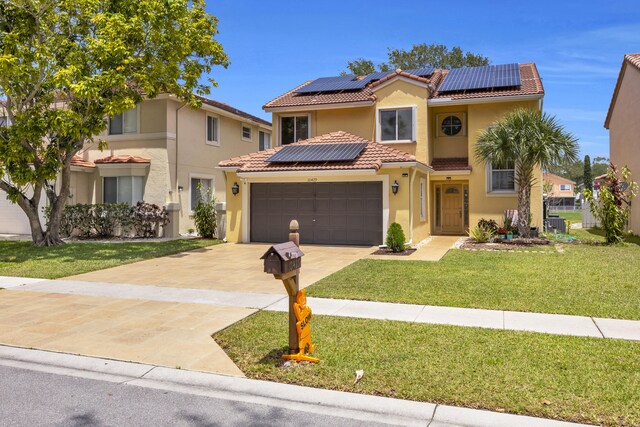 view of front of home featuring a front lawn, stucco siding, concrete driveway, a tile roof, and solar panels