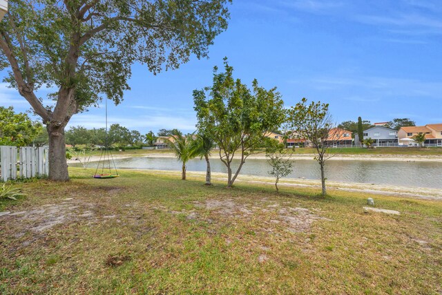 view of yard with a water view, fence, and a residential view