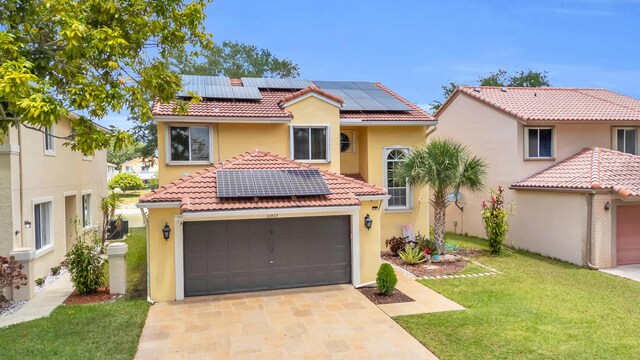 mediterranean / spanish-style house featuring stucco siding, solar panels, a tiled roof, and a front yard