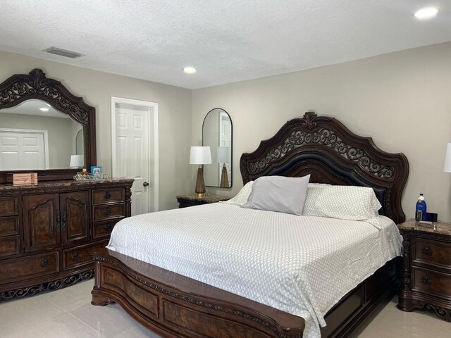 bedroom with visible vents, recessed lighting, and a textured ceiling