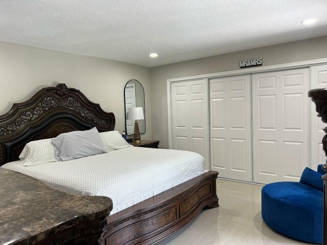 bedroom with a closet, recessed lighting, and a textured ceiling