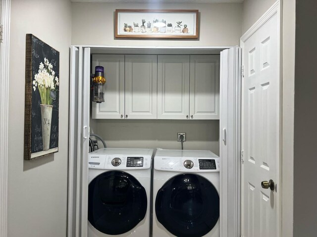 washroom with cabinet space and washing machine and dryer
