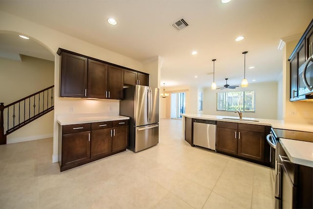 kitchen featuring appliances with stainless steel finishes, a sink, dark brown cabinets, light countertops, and recessed lighting