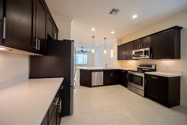 kitchen featuring stainless steel appliances, a peninsula, light countertops, crown molding, and dark brown cabinets
