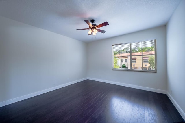 unfurnished room featuring a ceiling fan, baseboards, dark wood finished floors, and a textured ceiling