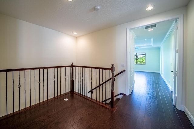 hall featuring an upstairs landing, wood-type flooring, baseboards, and recessed lighting