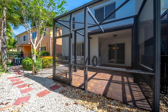 rear view of house with a patio, a lanai, and stucco siding