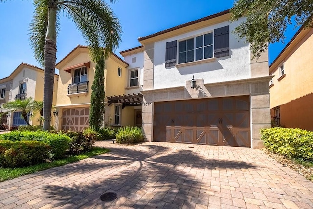 view of front of house with an attached garage, stucco siding, decorative driveway, and a tile roof