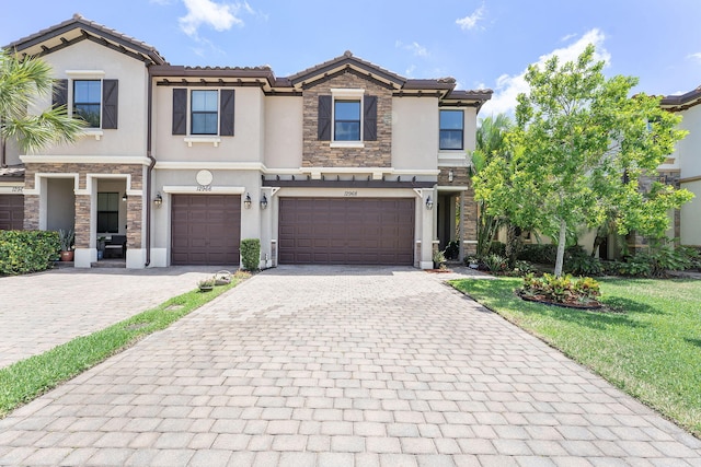 12968 Anthorne Ln, Boynton Beach, FL 33436 - view of property featuring stone siding, a garage, stucco siding, decorative driveway, and a tiled roof