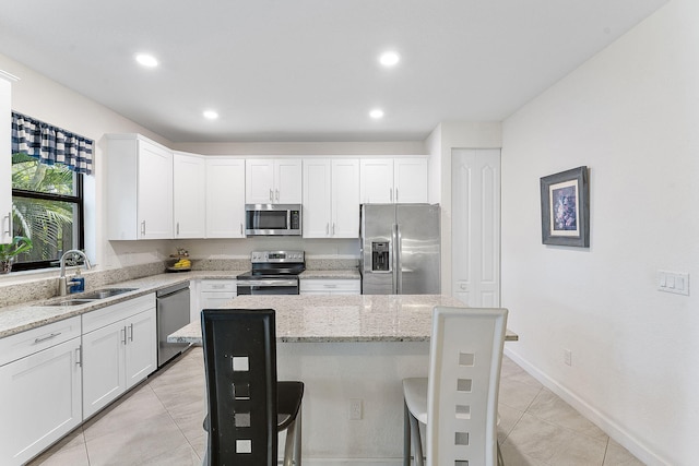 12968 Anthorne Ln, Boynton Beach, FL 33436 - kitchen featuring light tile patterned flooring, light stone countertops, white cabinetry, a sink, and stainless steel appliances