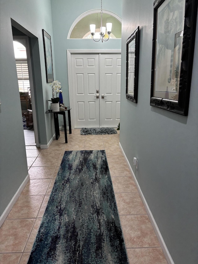 3237 El Camino Real, West Palm Beach, FL 33409 - foyer featuring baseboards, light tile patterned floors, and a notable chandelier