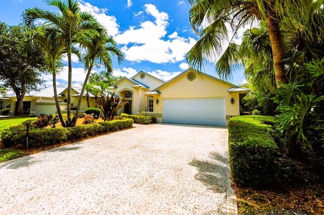 761 SW Lighthouse Dr, Palm City, FL 34990 - view of front facade with an attached garage, driveway, and stucco siding