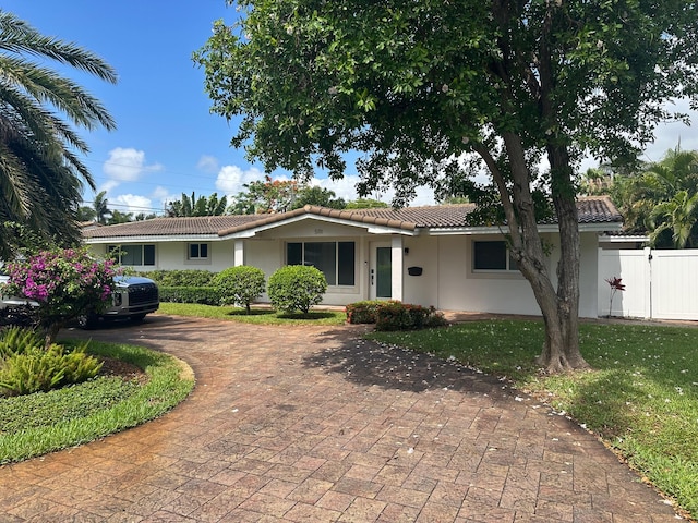 5111 NE 27th Ter NE, Lighthouse Point, FL 33064 - ranch-style home with curved driveway, a tiled roof, stucco siding, and a gate