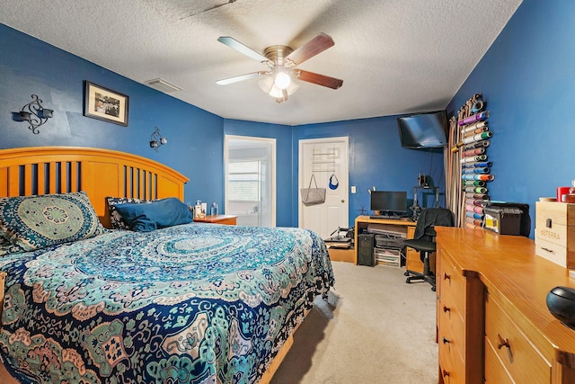 bedroom featuring visible vents, carpet flooring, a textured ceiling, and ceiling fan