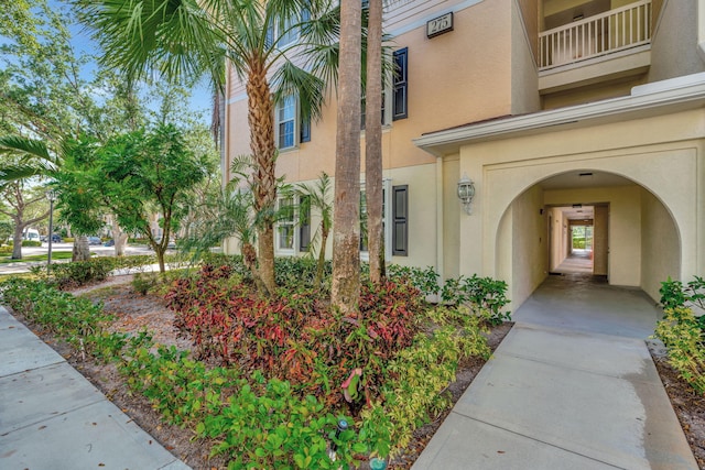 entrance to property featuring a balcony and stucco siding