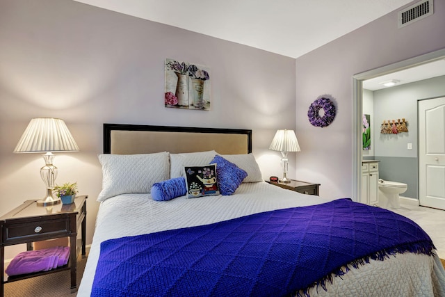 bedroom featuring baseboards, visible vents, ensuite bathroom, and carpet