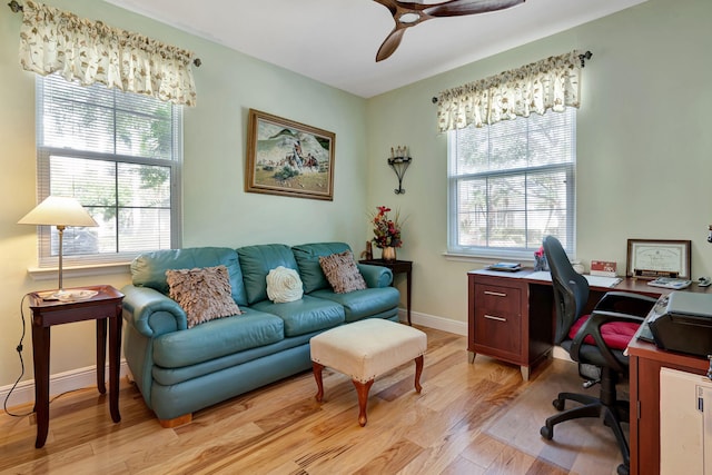 office area featuring light wood-type flooring, baseboards, ceiling fan, and a healthy amount of sunlight