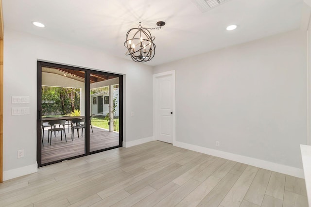 spare room with visible vents, recessed lighting, light wood finished floors, a notable chandelier, and baseboards