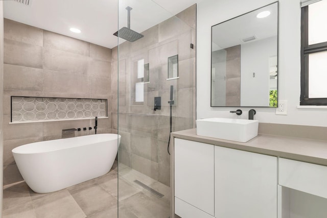 full bathroom featuring visible vents, a freestanding tub, walk in shower, vanity, and recessed lighting