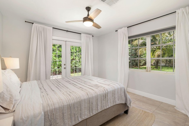 bedroom featuring multiple windows, access to outside, baseboards, and visible vents