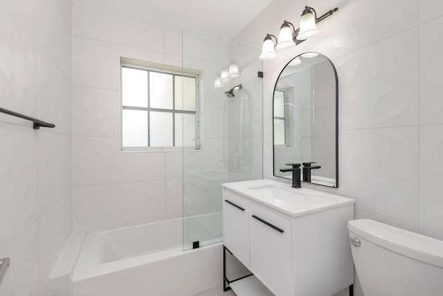 full bath with vanity, toilet, tub / shower combination, and tile walls