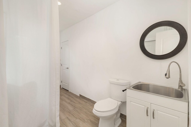 full bathroom with toilet, vanity, and wood finished floors