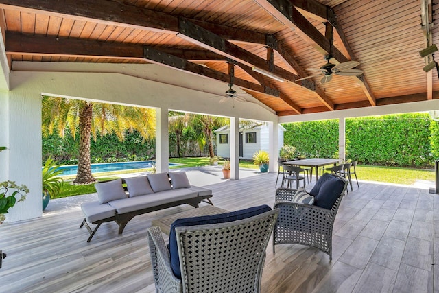 deck with an outdoor pool, a storage unit, an outbuilding, a ceiling fan, and outdoor dining area