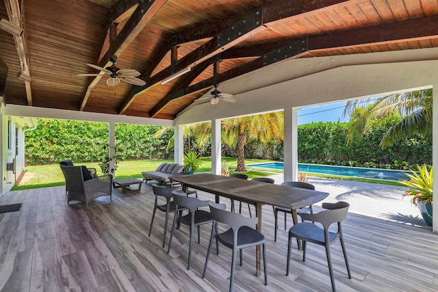 deck with a ceiling fan, a yard, and an outdoor pool