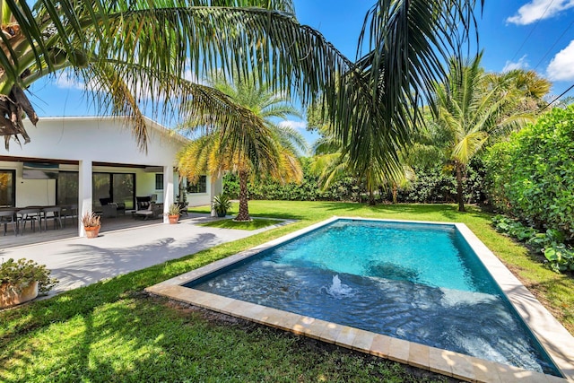 outdoor pool featuring a patio and a lawn