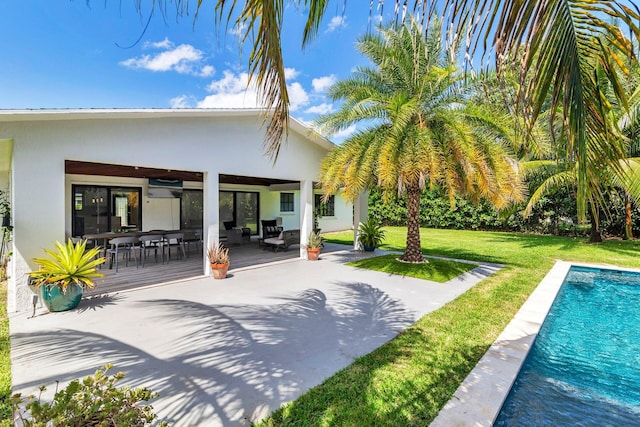 back of house with a lawn, an outdoor living space, stucco siding, and an outdoor pool