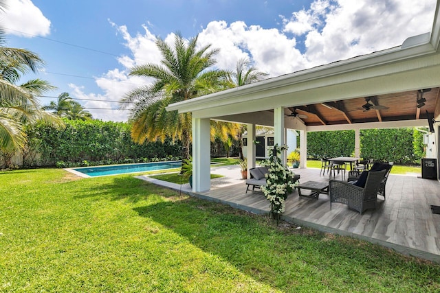 view of yard with a wooden deck, an outdoor pool, and ceiling fan