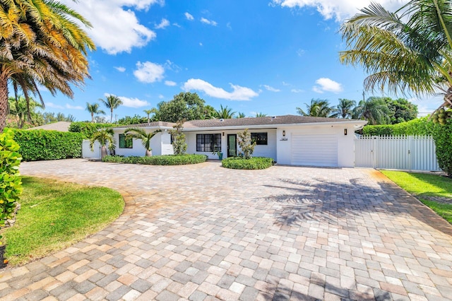 single story home with fence, a garage, stucco siding, curved driveway, and a gate