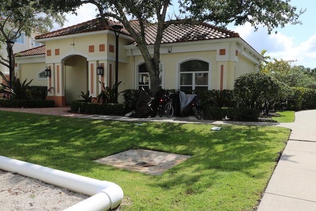9825 Baywinds Dr Unit 1208, West Palm Beach, FL 33411 - mediterranean / spanish house featuring a tiled roof, a front yard, and stucco siding