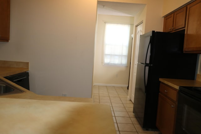 9825 Baywinds Dr Unit 1208, West Palm Beach, FL 33411 - kitchen featuring black electric range, light tile patterned flooring, brown cabinets, light countertops, and baseboards
