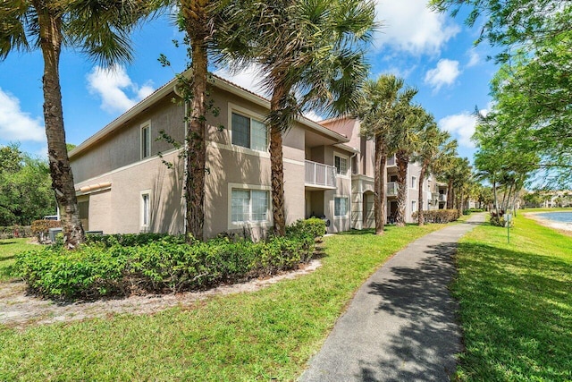 5031 Wiles Rd Unit 104, Coconut Creek, FL 33073 - view of side of property with a lawn and stucco siding