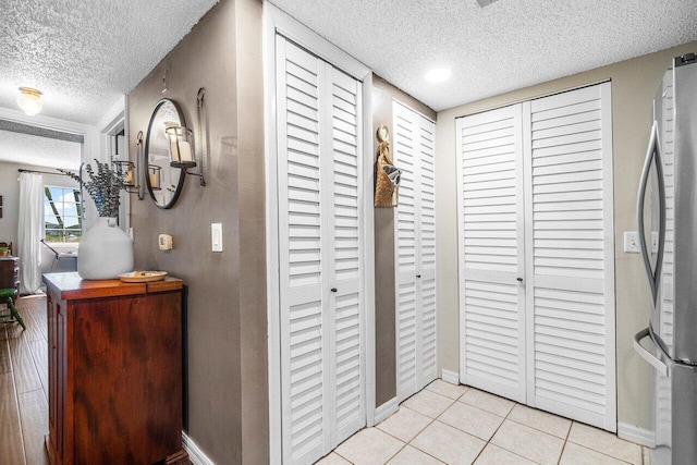5031 Wiles Rd Unit 104, Coconut Creek, FL 33073 - corridor featuring baseboards, a textured ceiling, and light tile patterned flooring