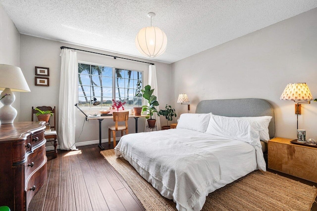 5031 Wiles Rd Unit 104, Coconut Creek, FL 33073 - bedroom featuring a textured ceiling, baseboards, and hardwood / wood-style floors