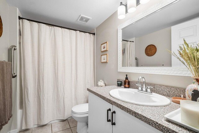 5031 Wiles Rd Unit 104, Coconut Creek, FL 33073 - bathroom with visible vents, tile patterned flooring, double vanity, toilet, and a sink