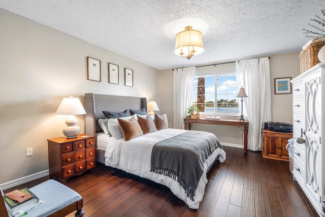 5031 Wiles Rd Unit 104, Coconut Creek, FL 33073 - bedroom featuring baseboards, a textured ceiling, and dark wood finished floors