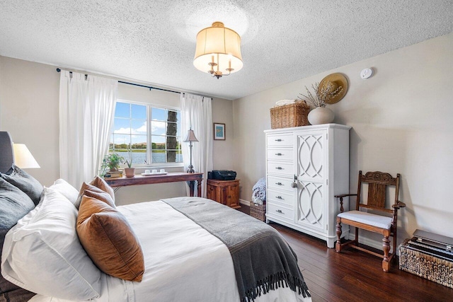 5031 Wiles Rd Unit 104, Coconut Creek, FL 33073 - bedroom featuring a textured ceiling and dark wood-style flooring