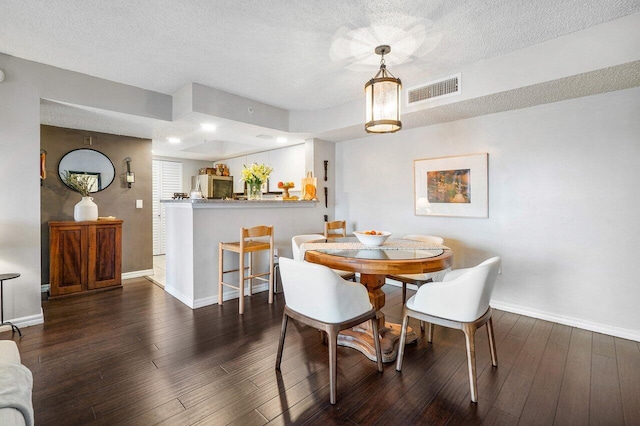 5031 Wiles Rd Unit 104, Coconut Creek, FL 33073 - dining room with a textured ceiling, baseboards, visible vents, and hardwood / wood-style flooring