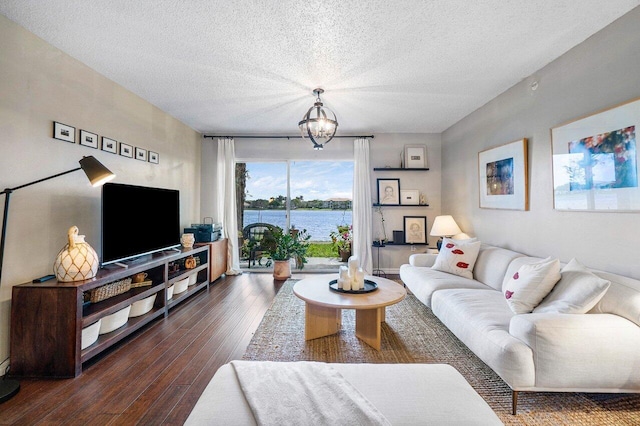 5031 Wiles Rd Unit 104, Coconut Creek, FL 33073 - living room featuring dark wood-style flooring, a textured ceiling, and a notable chandelier