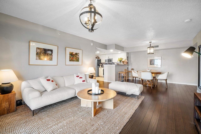 5031 Wiles Rd Unit 104, Coconut Creek, FL 33073 - living area featuring an inviting chandelier, a textured ceiling, baseboards, and hardwood / wood-style floors