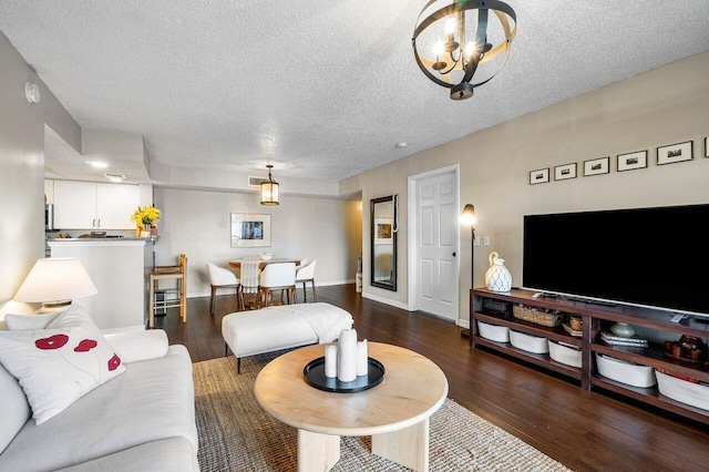 5031 Wiles Rd Unit 104, Coconut Creek, FL 33073 - living room featuring baseboards, a textured ceiling, an inviting chandelier, and wood finished floors