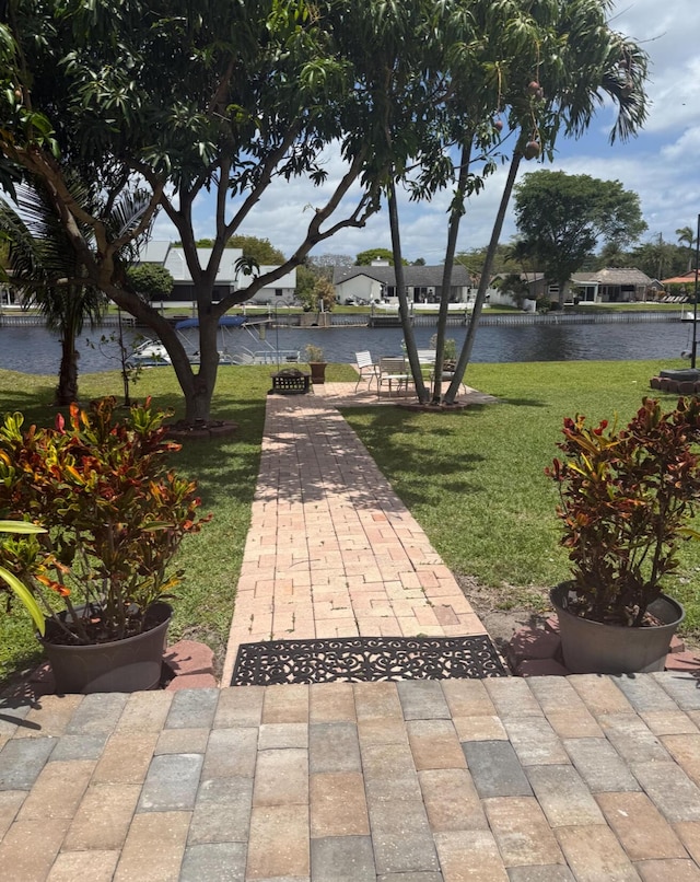 view of home's community featuring a water view and a yard