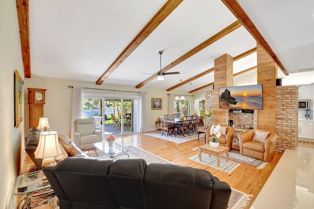 living area with vaulted ceiling with beams, a ceiling fan, and wood finished floors