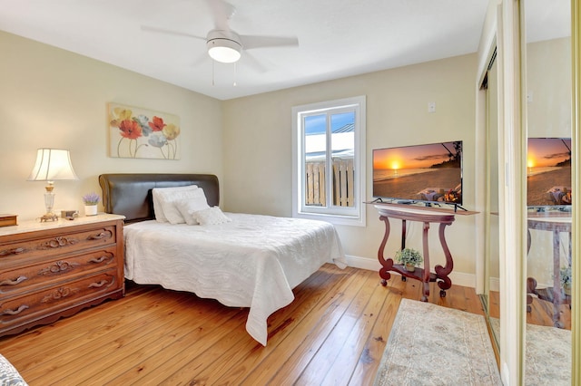 bedroom with a ceiling fan, baseboards, and light wood-type flooring