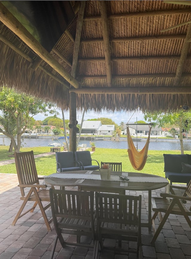 view of patio / terrace featuring a gazebo, a water view, and outdoor dining area